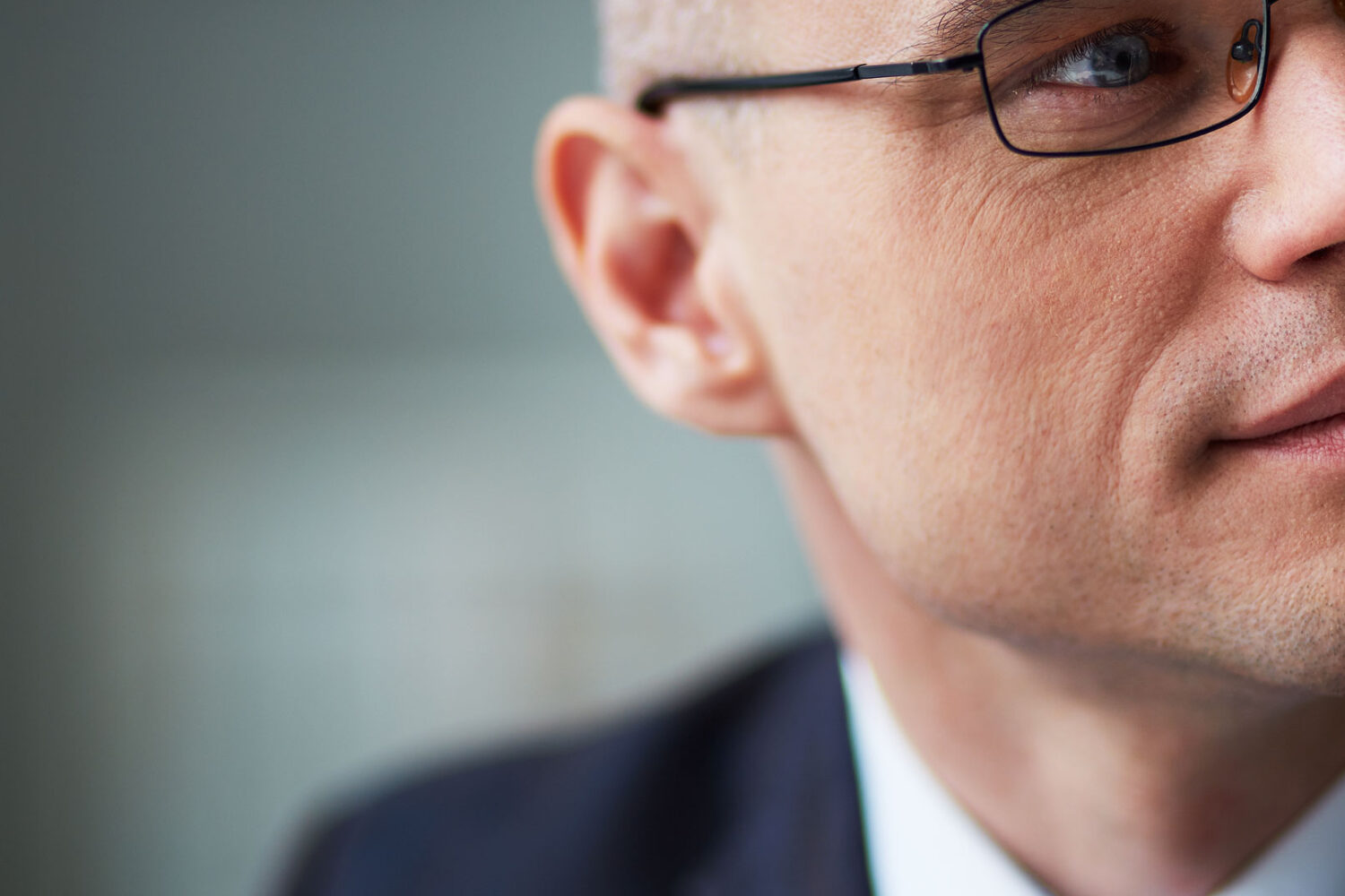 Stock image close up of the side of a man's face. He is wearing a suit and glasses. Six agreements that make your workplace work graphic - the 4 quardrants are strategy, structure, people and process. THe six agreements are Control emotions, acknowledge, listen, speak straight, be accountable, give support. Image is used to promote The Collaboration Company, CCO, Northern Ireland