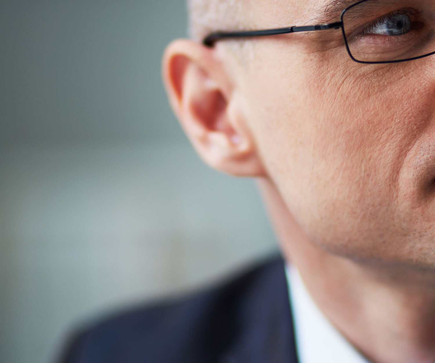 Stock image close up of the side of a man's face. He is wearing a suit and glasses. Six agreements that make your workplace work graphic - the 4 quardrants are strategy, structure, people and process. THe six agreements are Control emotions, acknowledge, listen, speak straight, be accountable, give support. Image is used to promote The Collaboration Company, CCO, Northern Ireland