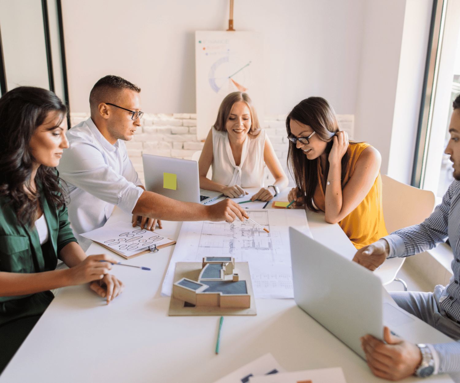 A group of coworkers sat around a table discussing a project.