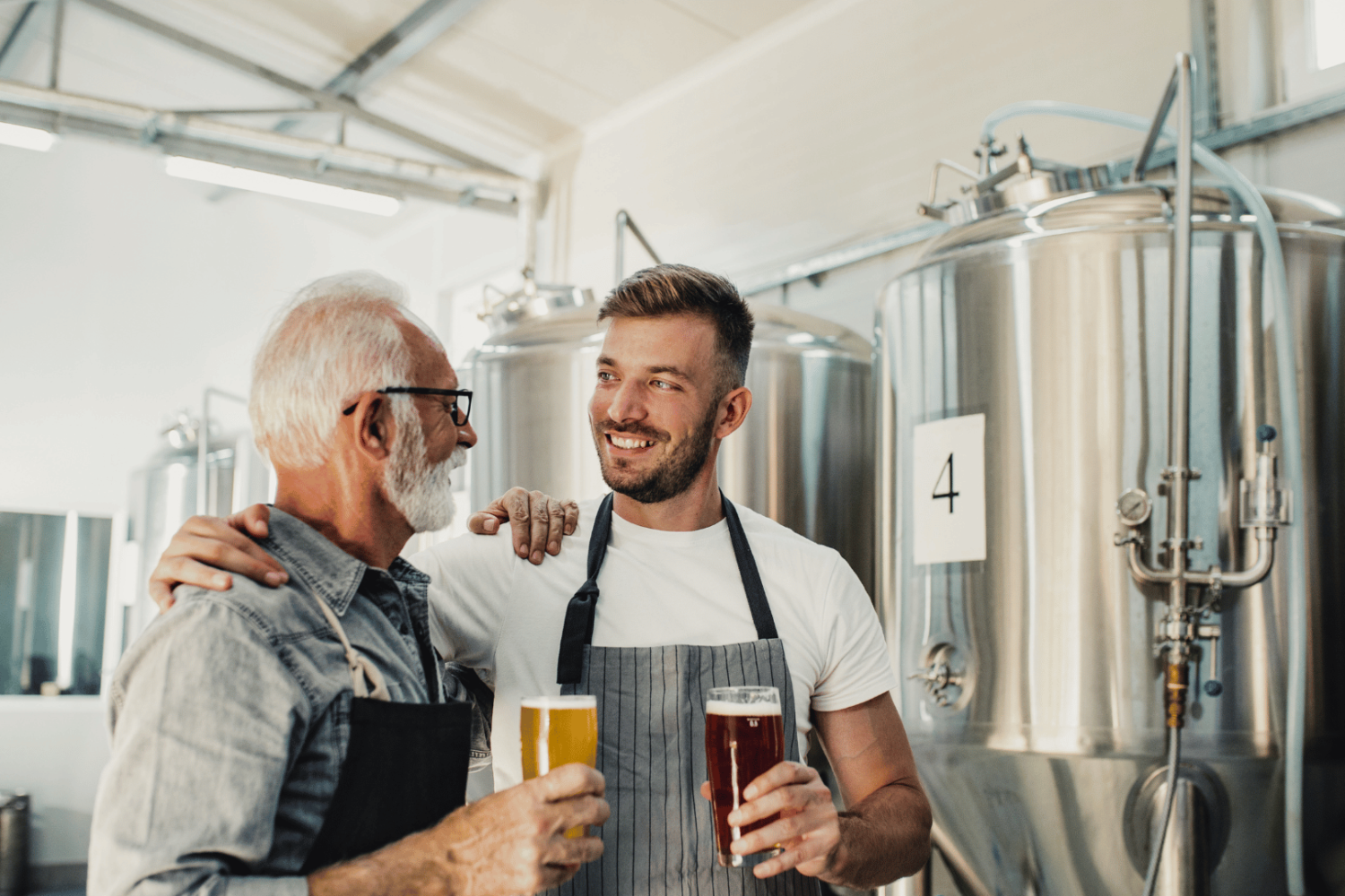 Older man with a younger man running a brewery