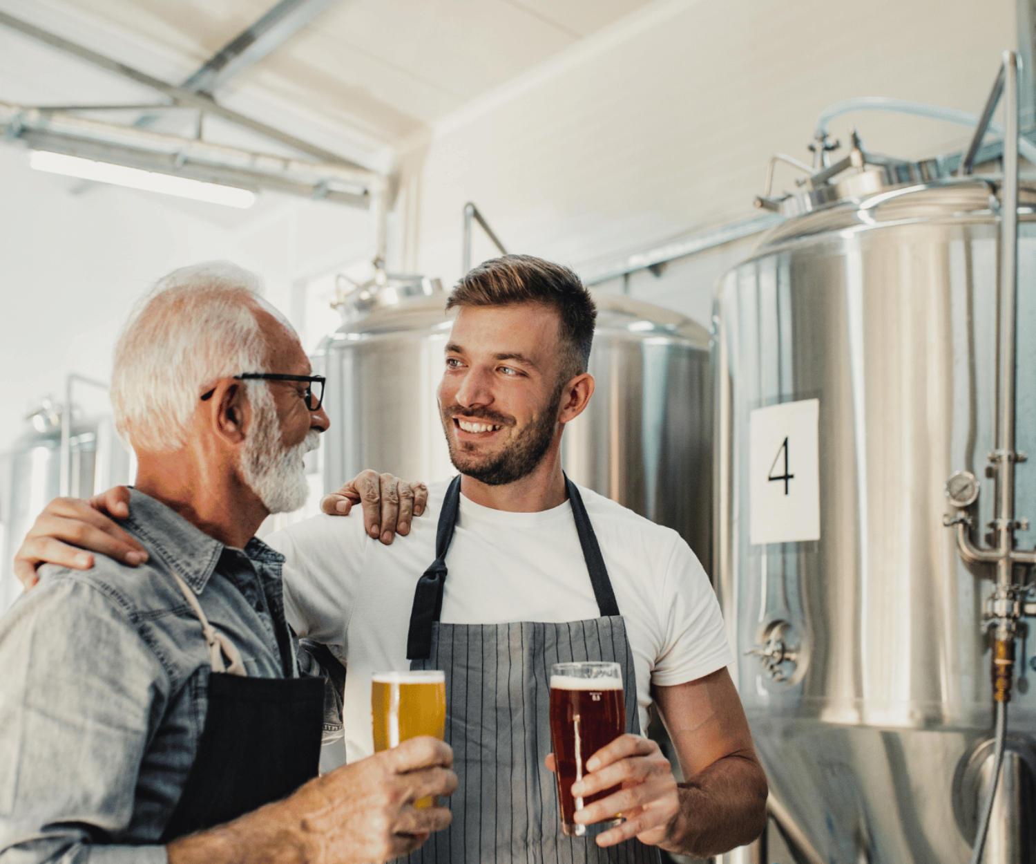 Older man with a younger man running a brewery