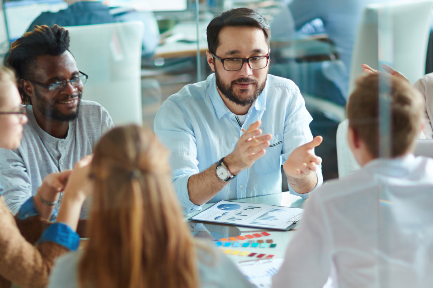 a stock image of work coleagues sitting around a table working collaboratively