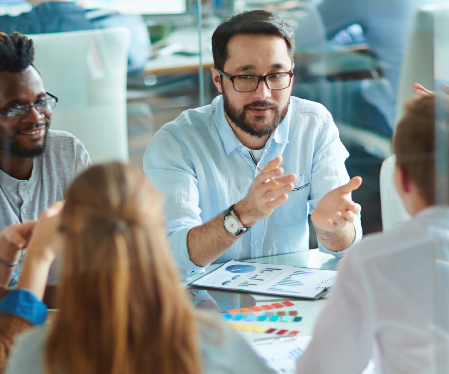 a stock image of work coleagues sitting around a table working collaboratively